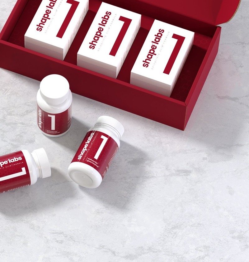 Ge&ouml;ffnete shape labs ONE Versandbox mit drei Produktboxen f&uuml;r die 30-Tage-Kur, davor mehrere lose Dosen